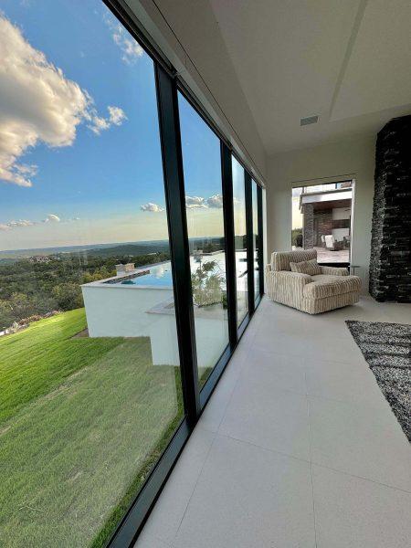 Modern Luxury Hill Top Floor to Ceiling Windows Lake Travis View Master Bedroom Zbranek and Holt Custom Homes