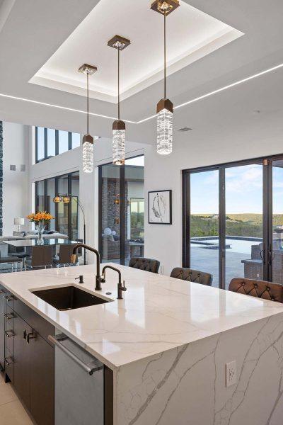 Modern Luxury Hill Top kitchen waterfall island double faucet pendant lighting pool view Zbranek and Holt Custom Homes