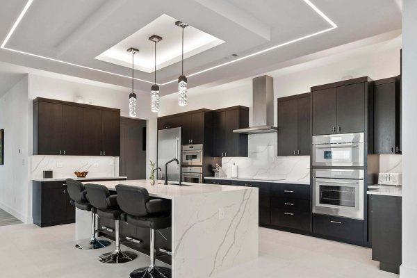 Modern Luxury Hill Top kitchen waterfall island recessed lighting dark cabinetry horz Zbranek and Holt Custom Homes