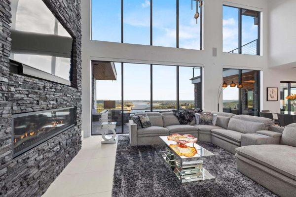 Modern Luxury Hill Top living room lake views stone fireplace glass walls Zbranek and Holt Custom Homes