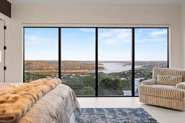 Modern Luxury Hill Top master bedroom panoramic lake travis view floor to ceiling windows Zbranek and Holt Custom Homes