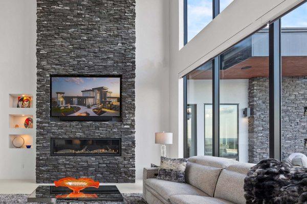 Modern Luxury Hill Top stone fireplace living room glass windows horz Zbranek and Holt Custom Homes